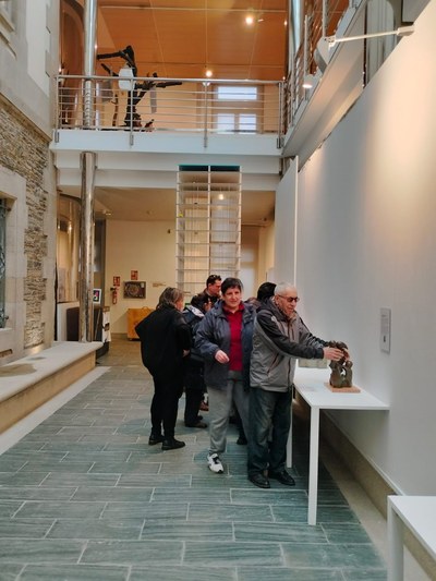Personas tocando las esculturas en la exposición