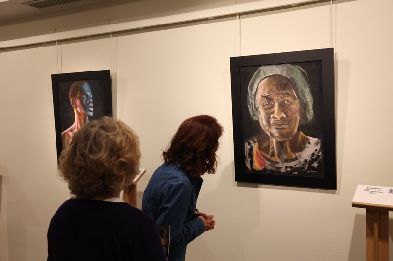 Dos personas mirando la obra de Lola Raya