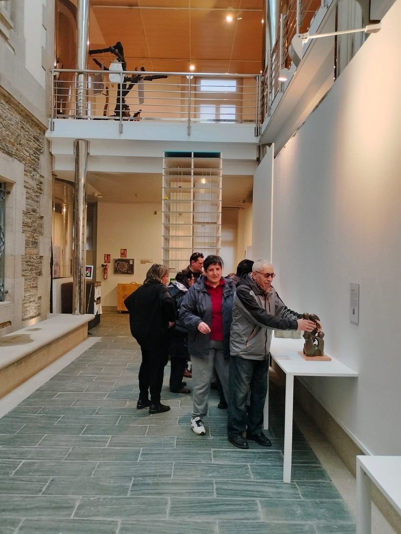 Personas tocando las esculturas en la exposición